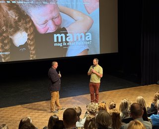 podium met 2 mensen en bioscoopscherm op achtergrond